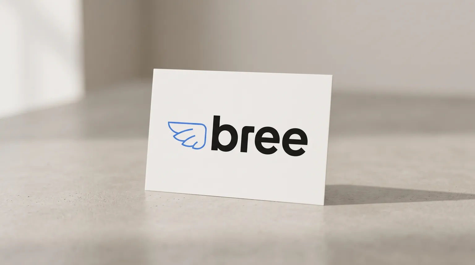 The Bree logo on a plain card resting on a pale grey concrete surface.