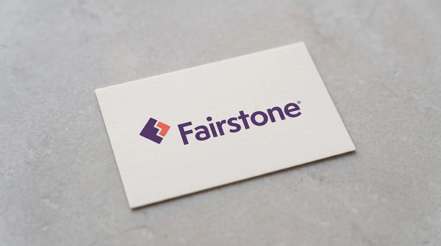 The Fairstone logo on a plain card resting on a pale stone surface under soft daylight.